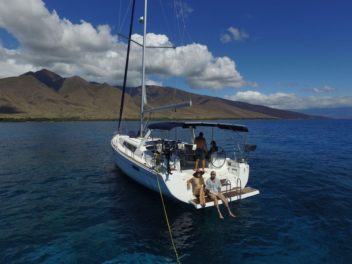 SV Kainani at anchor off West Maui, guests relaxing on the stern